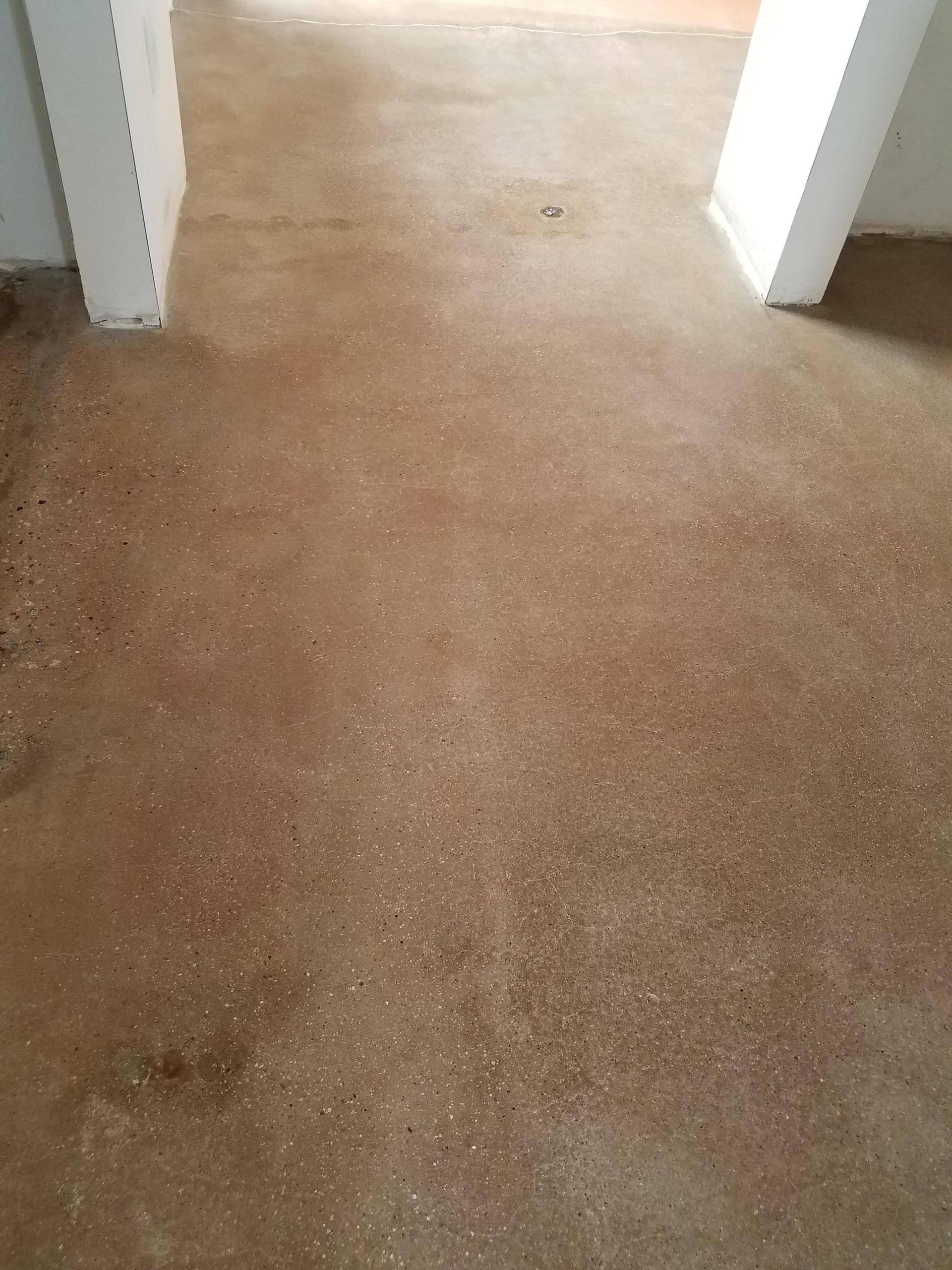 A close up of a concrete floor in a room with a doorway.