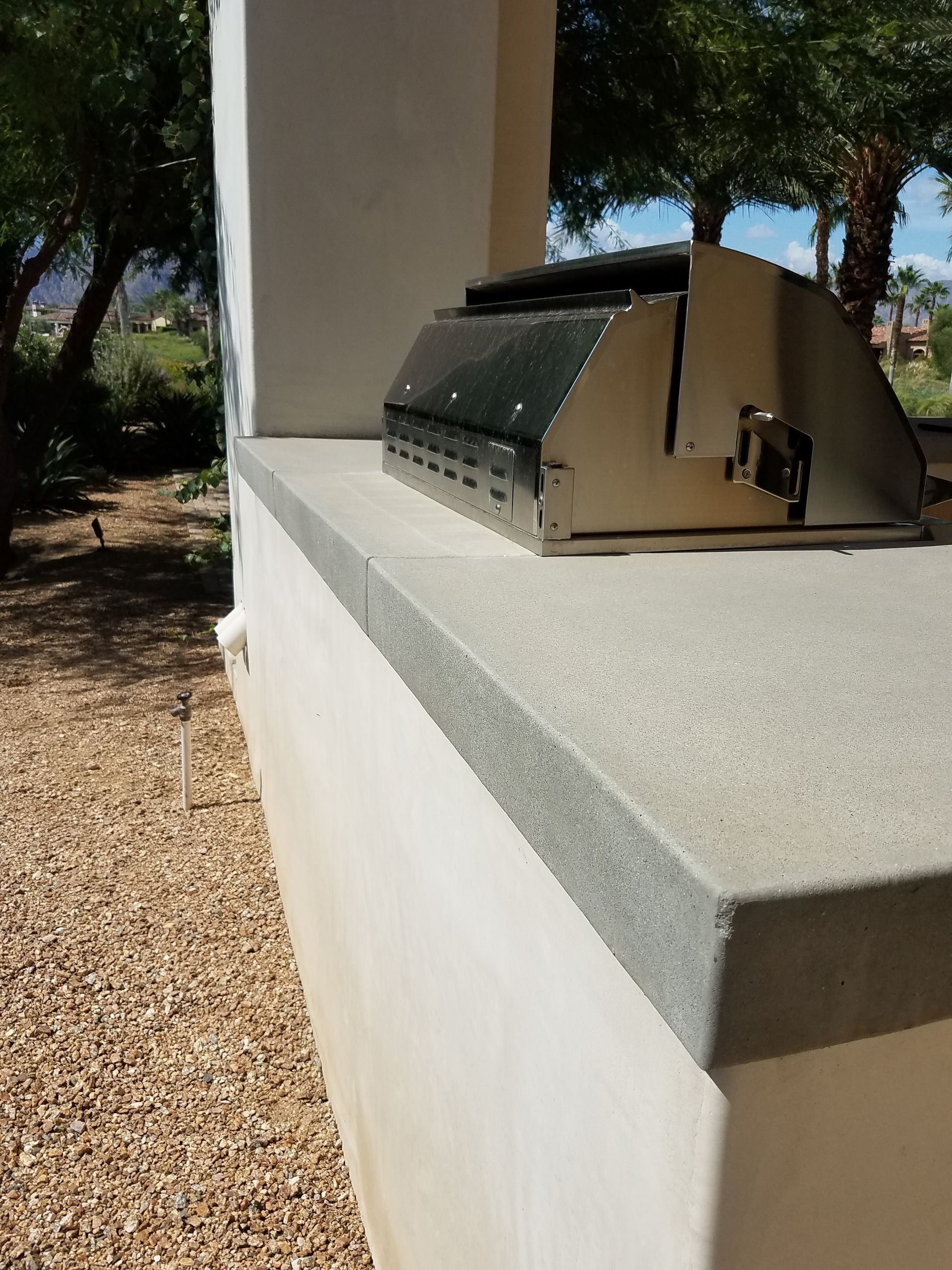 A grill is sitting on top of a counter outside