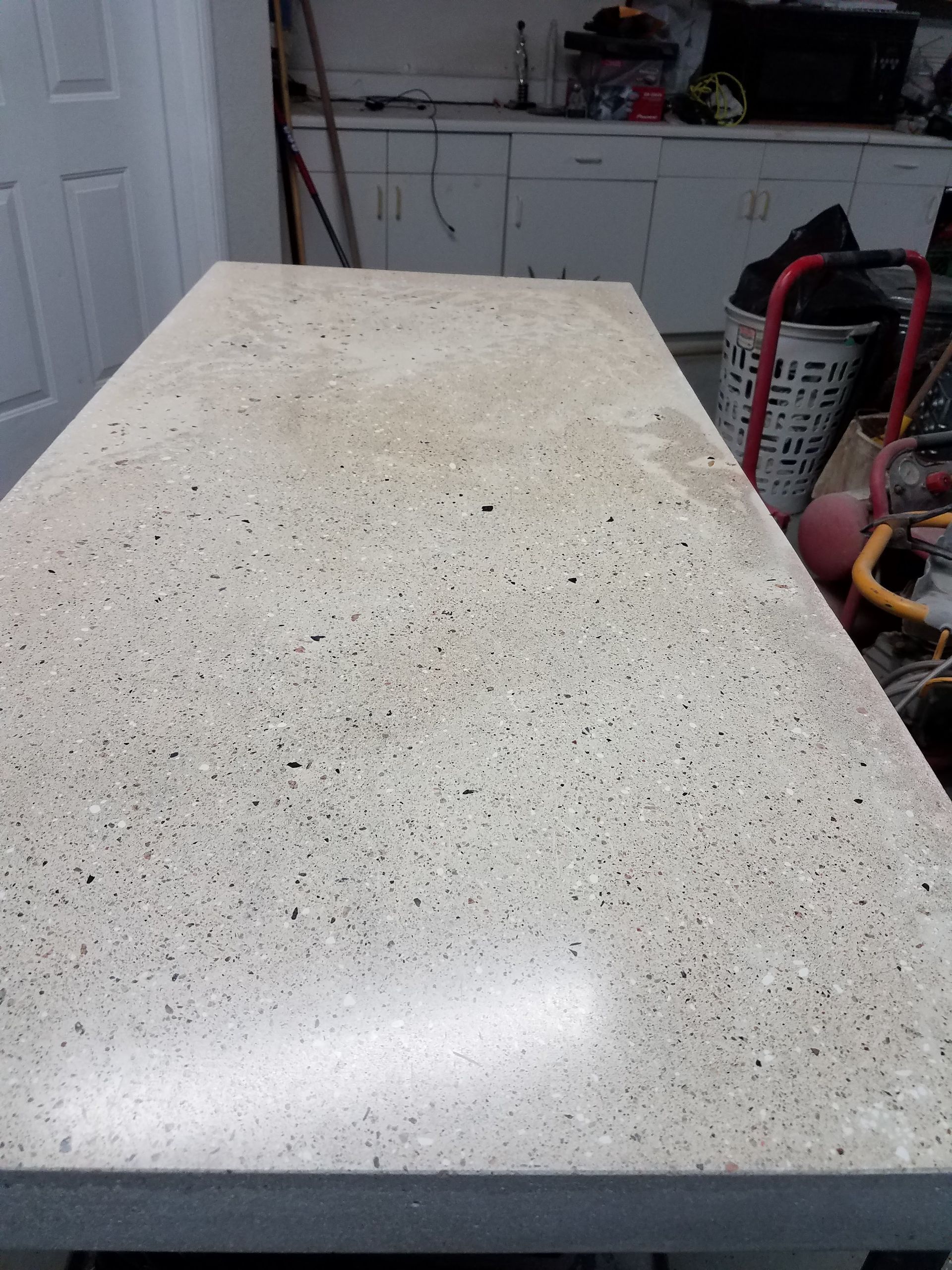 A white counter top with black spots on it in a kitchen