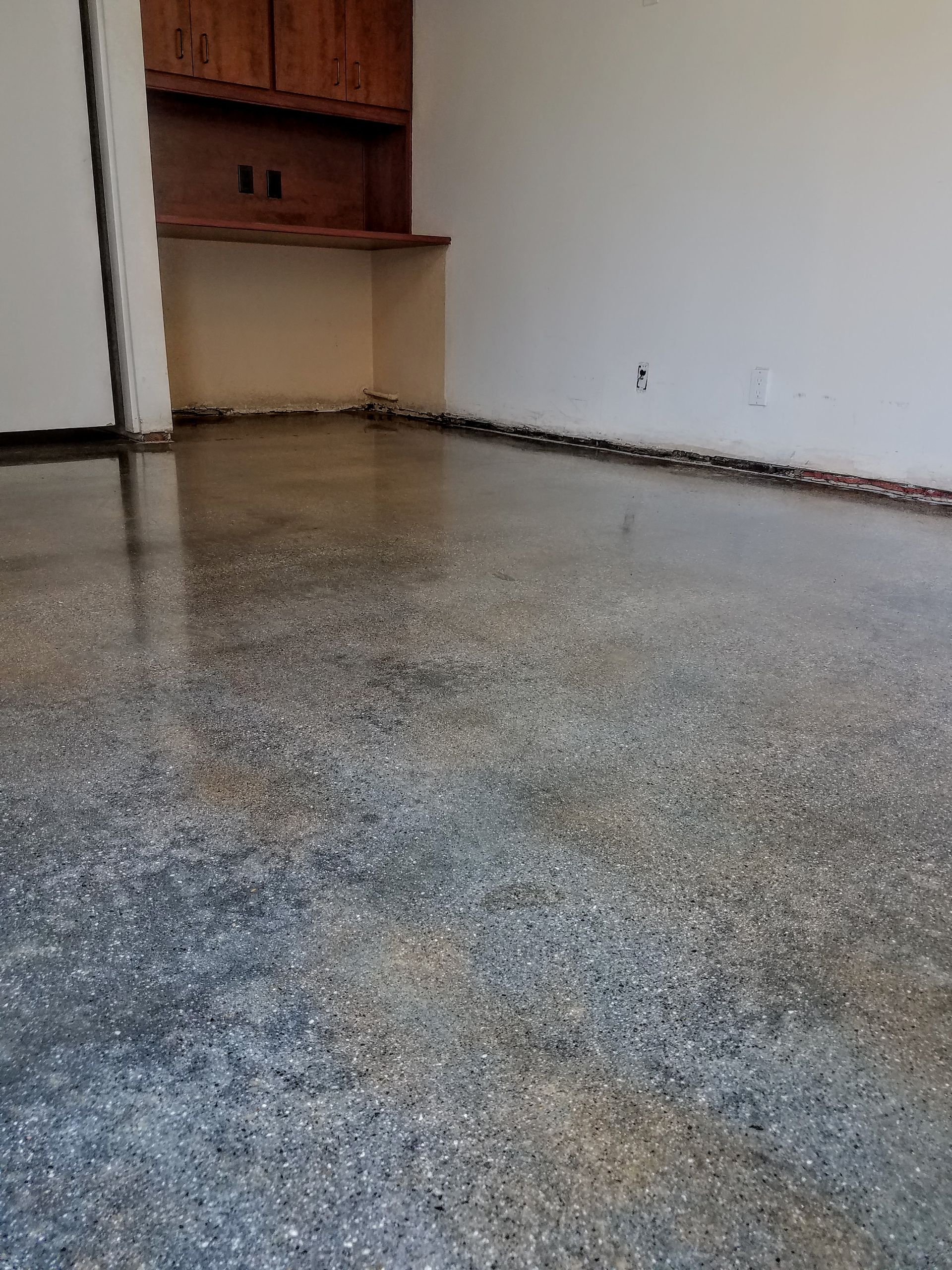 A room with a concrete floor and white walls.