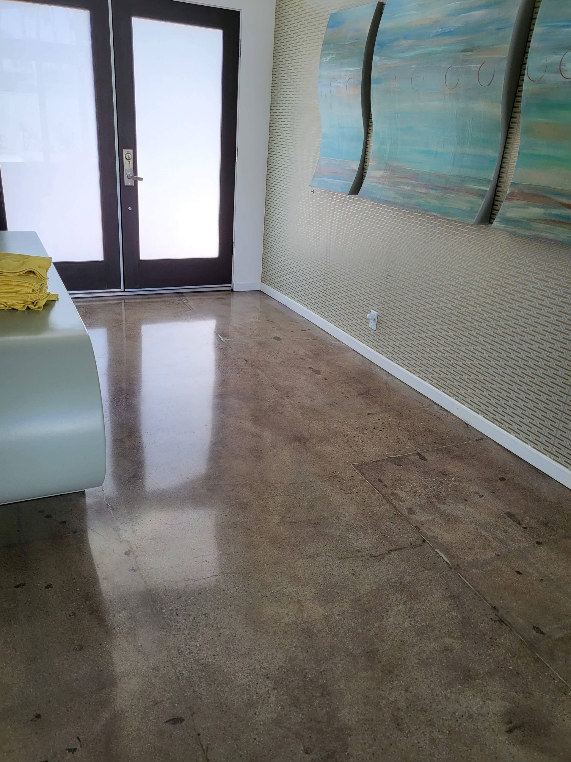 A living room with a couch and a painting on the wall.