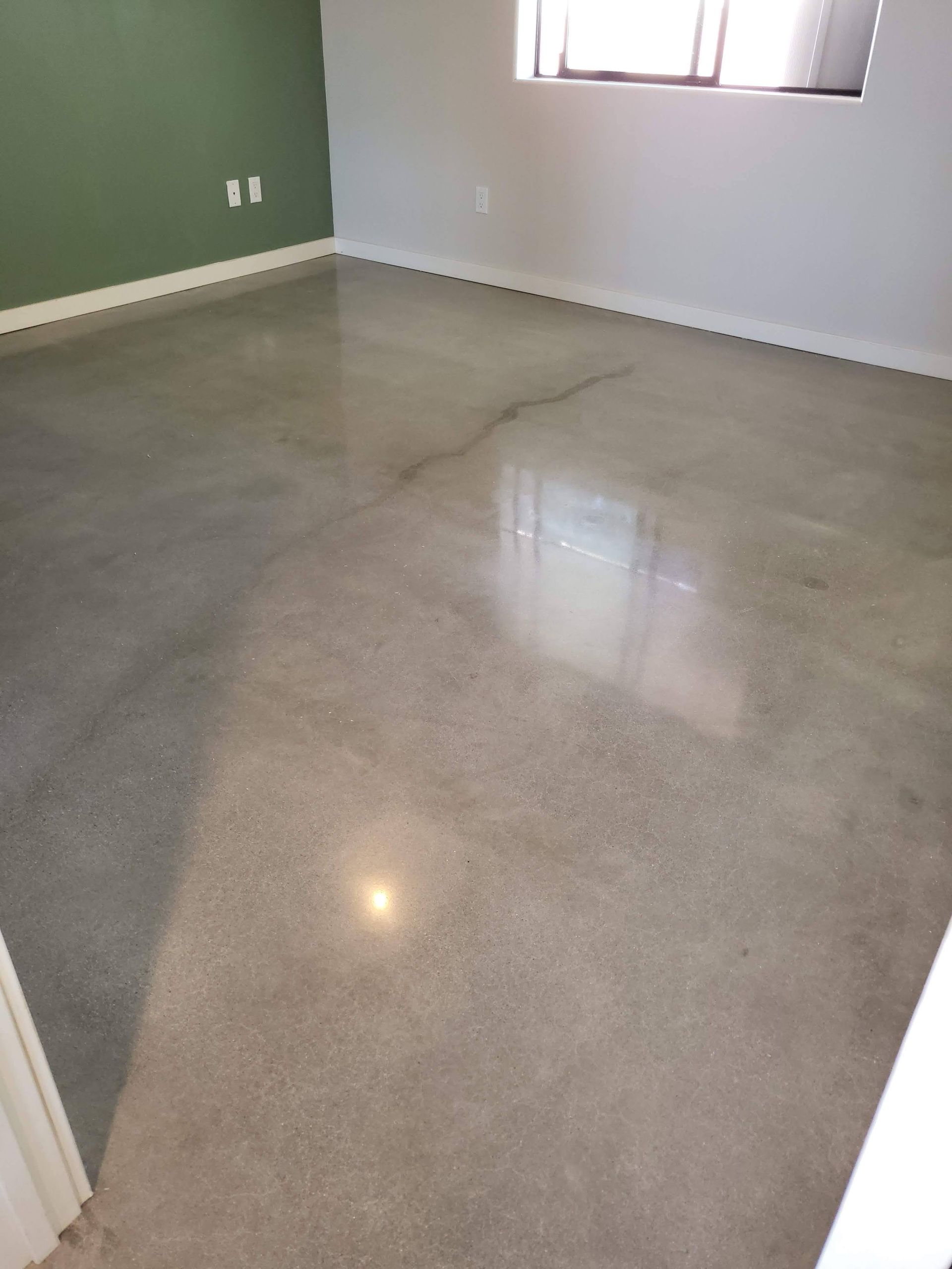 A room with a polished concrete floor and a window.