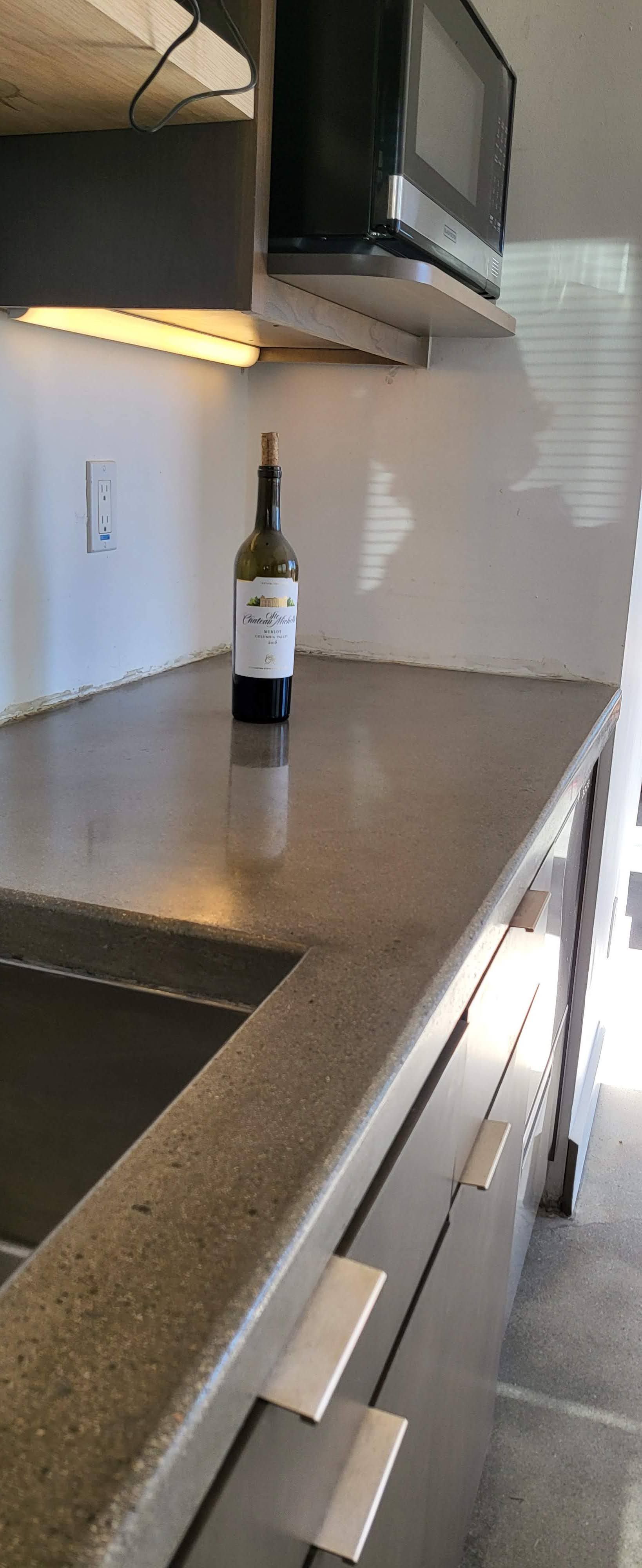 A bottle of wine is sitting on a counter in a kitchen.