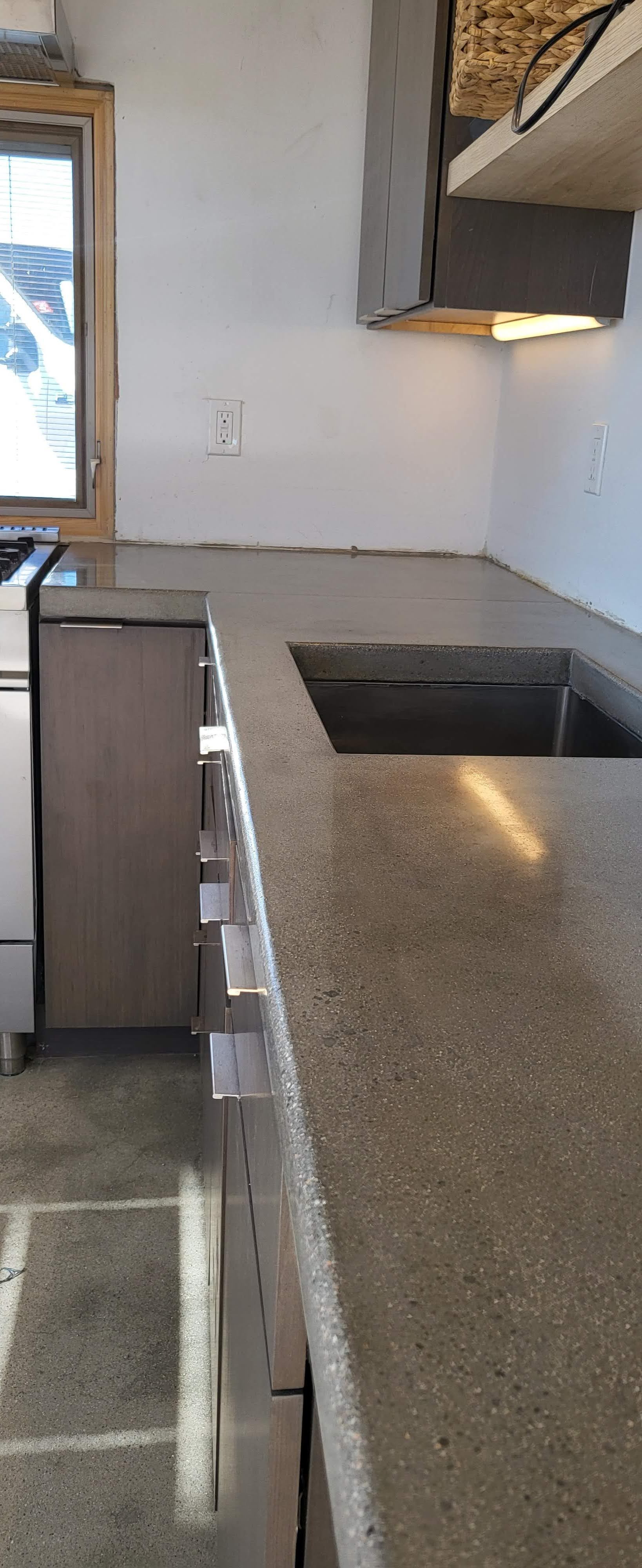 A kitchen with granite counter tops , stainless steel appliances , and a sink.