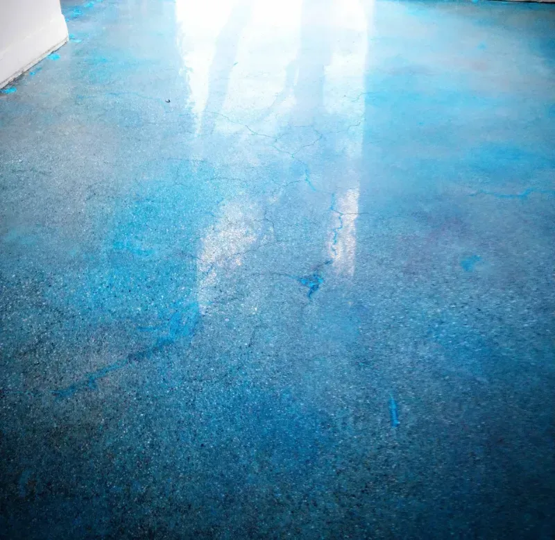 A close up of a blue concrete floor in a room.