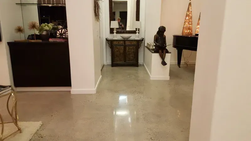 A living room with a piano and a statue on the floor.