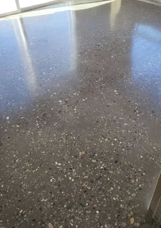 A close up of a concrete floor with a lot of small rocks on it.