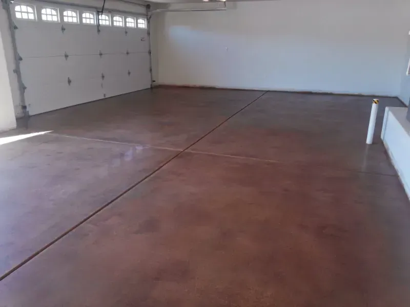 a large empty garage with a refinished concrete floor and a white garage door in Palm Springs CA.