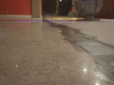 A person is polishing a concrete floor with a machine.