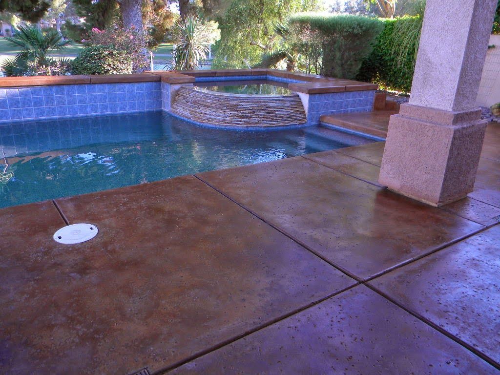 A patio with a swimming pool in the background