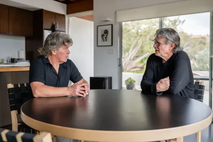 Michael Bonifazi and team are sitting at a concrete polished table in Yucca Valley Southern California talking to each other.