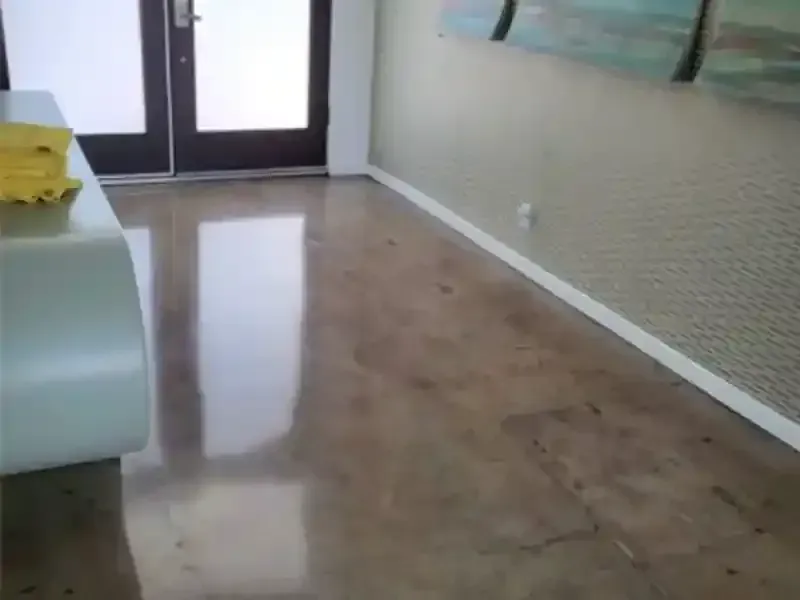 A hallway with concrete polished floors and a painting on the wall.