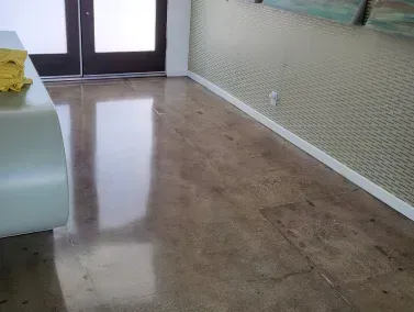 a room with a polished concrete floor, a table , and a door in a yucca valley CA residential home.