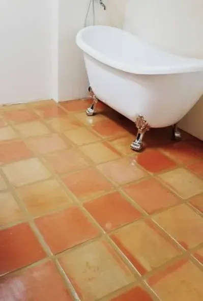 a bathtub is sitting on a cleaned grout and tiled floor in a bathroom in Yucca Valley, South California.