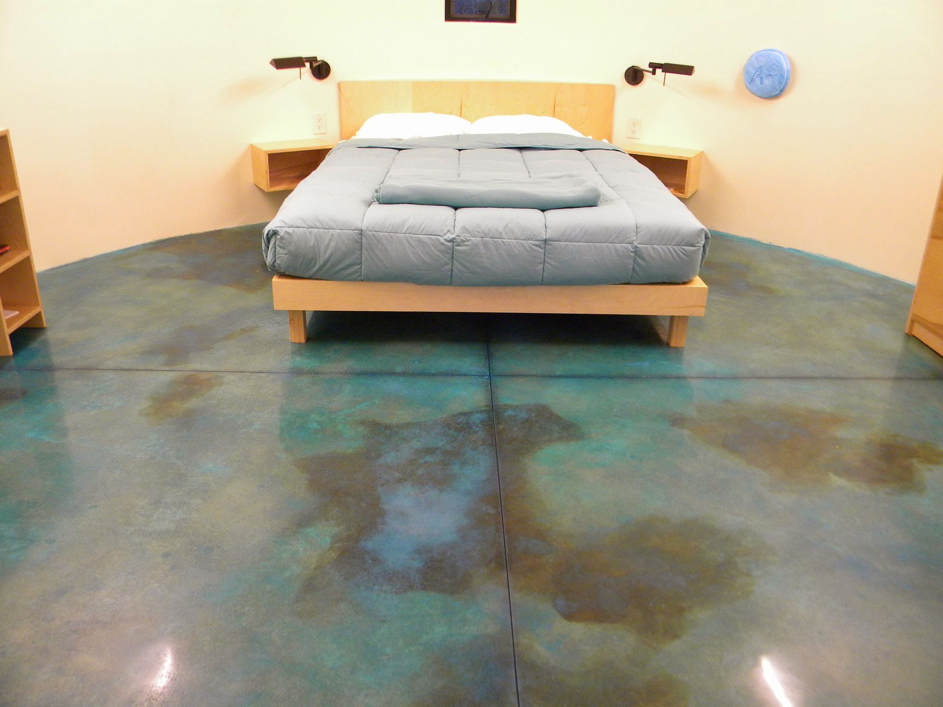 A bedroom with a bed and a blue floor
