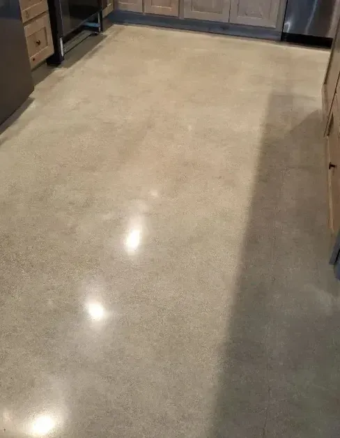 Polished concrete kitchen floor with cabinetry visible in the background.