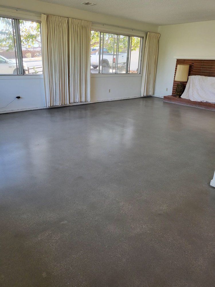 An empty living room with a polished concrete floor.