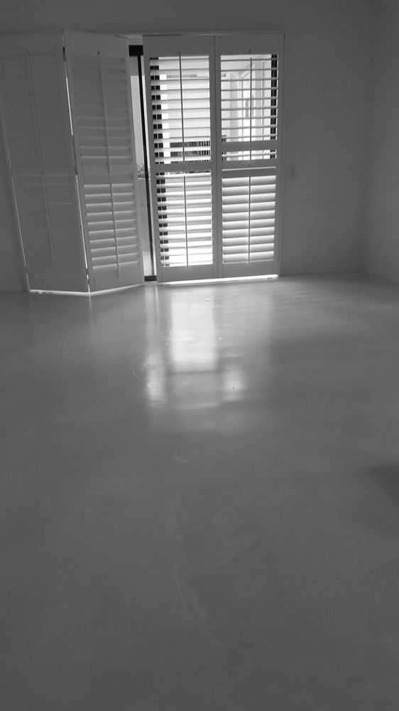A black-and-white photo of an empty room with a polished concrete floor