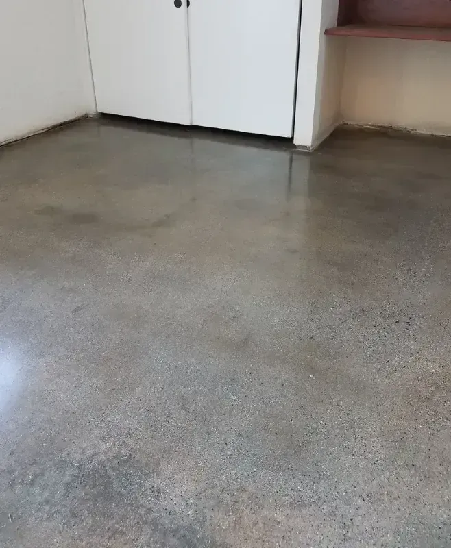 Polished concrete floor in a room with white doors and a brown shelf.