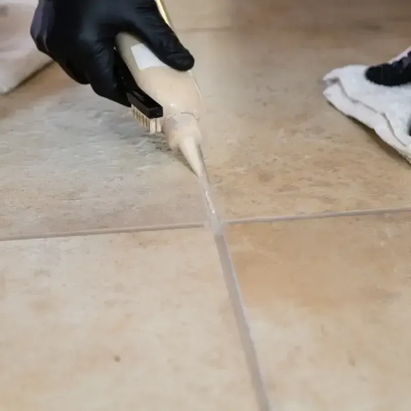 A person is cleaning a tile floor with a mop.