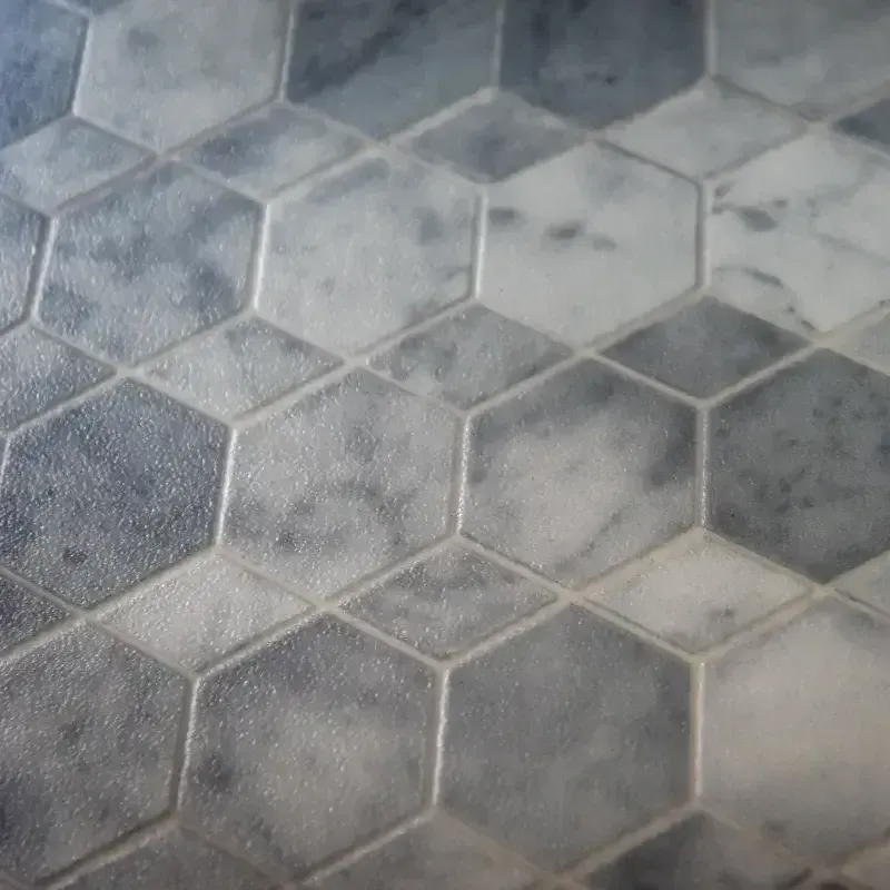 A close up of a gray and white hexagon tile floor.