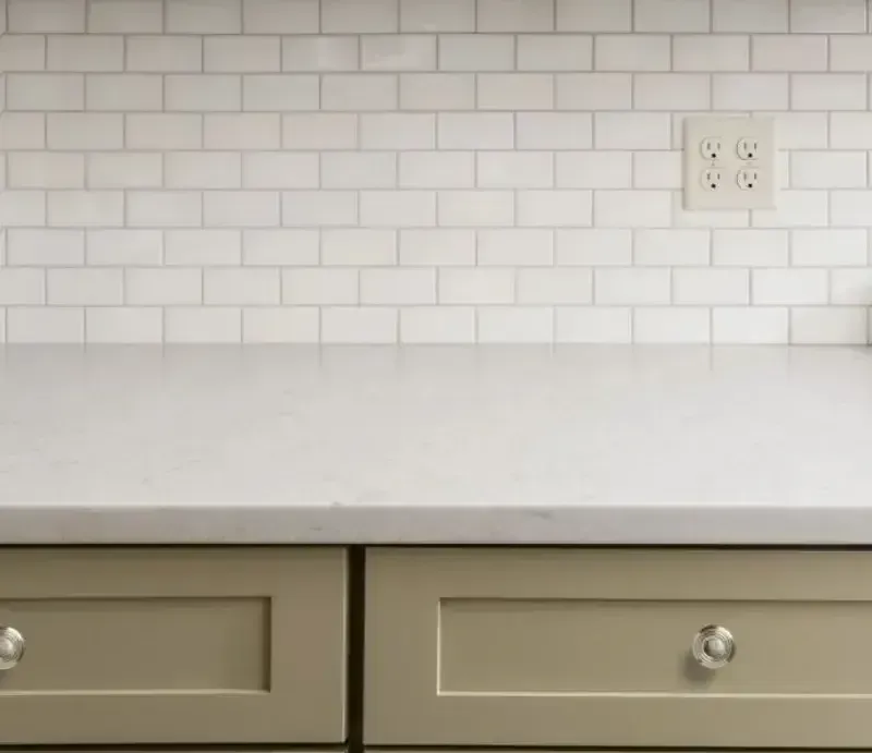 A kitchen counter with two drawers and a white counter top.