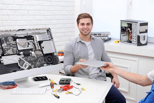 Man giving laptop to repairer Man giving laptop to repairer