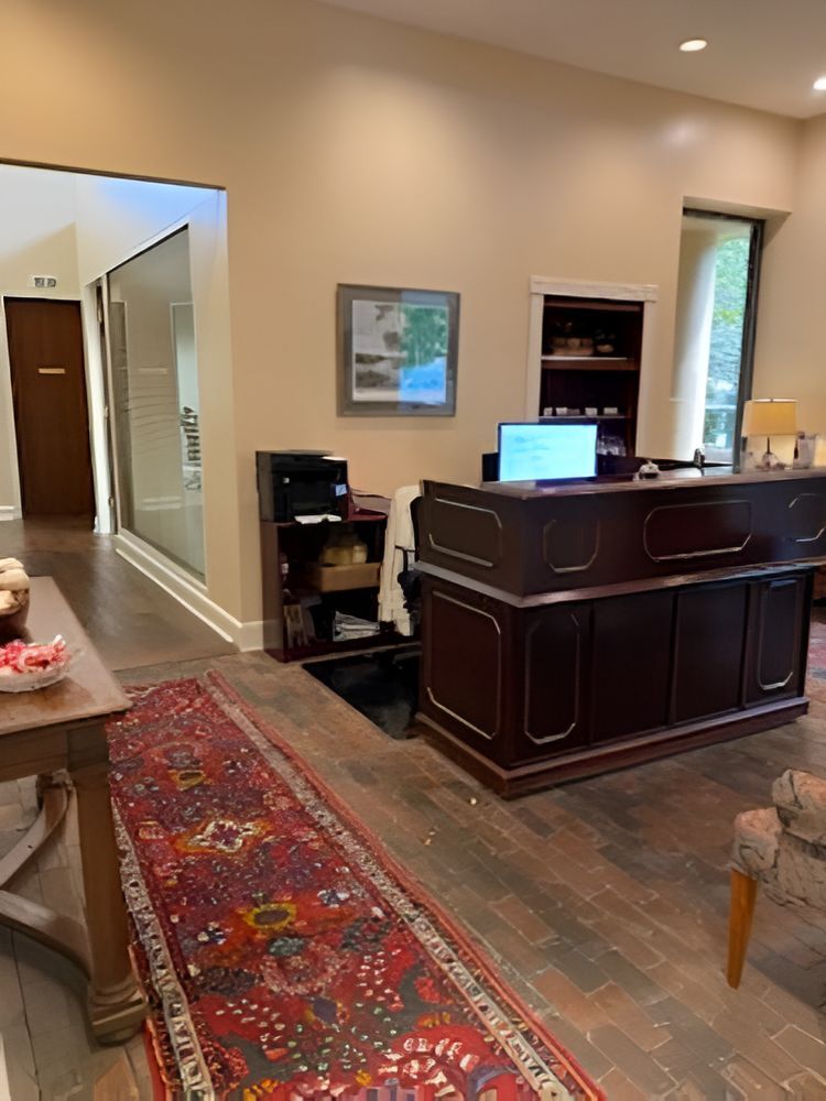 A nurse wearing headphones is having a video call on her laptop.