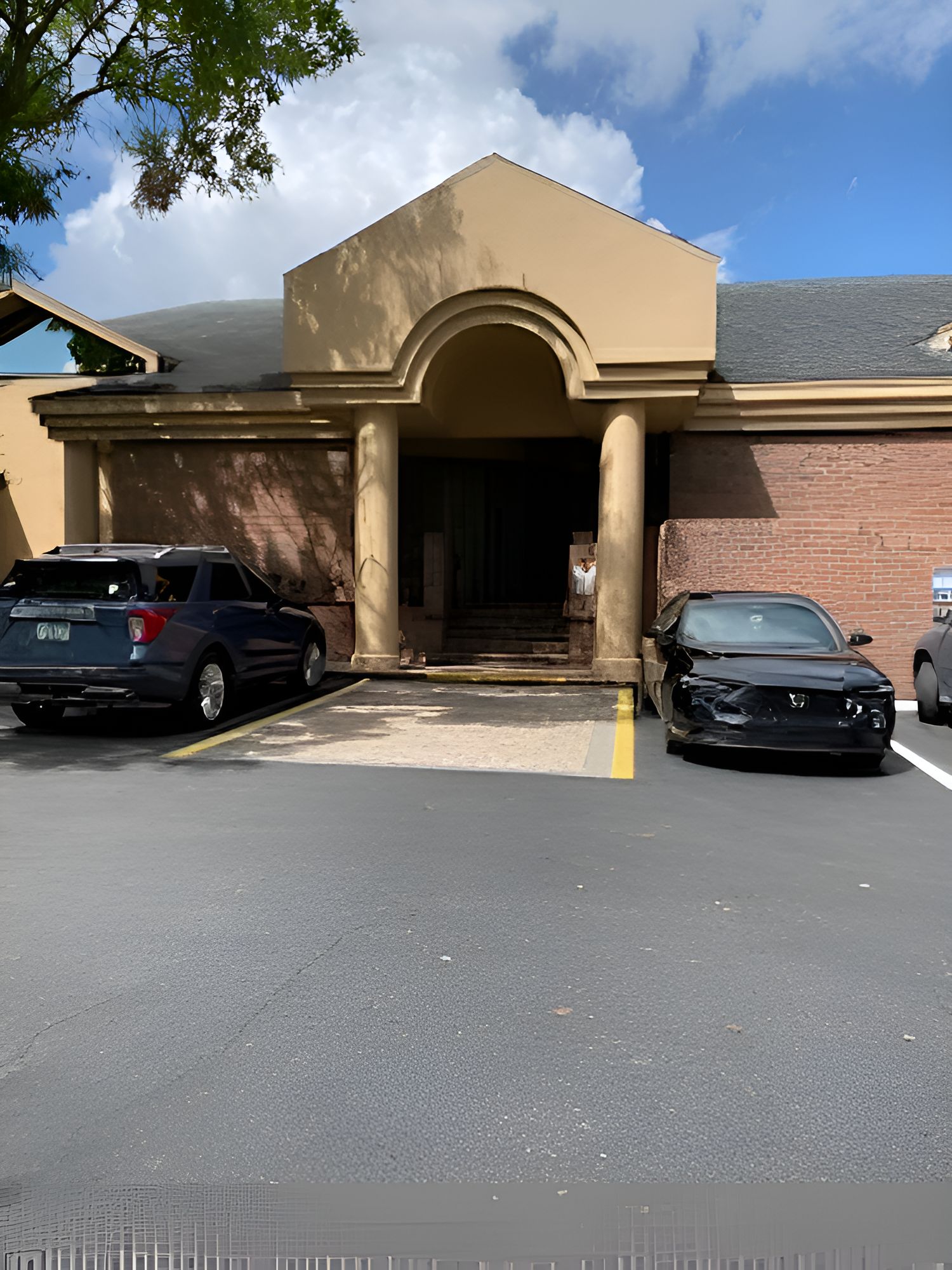 A row of cars are parked in a parking lot.