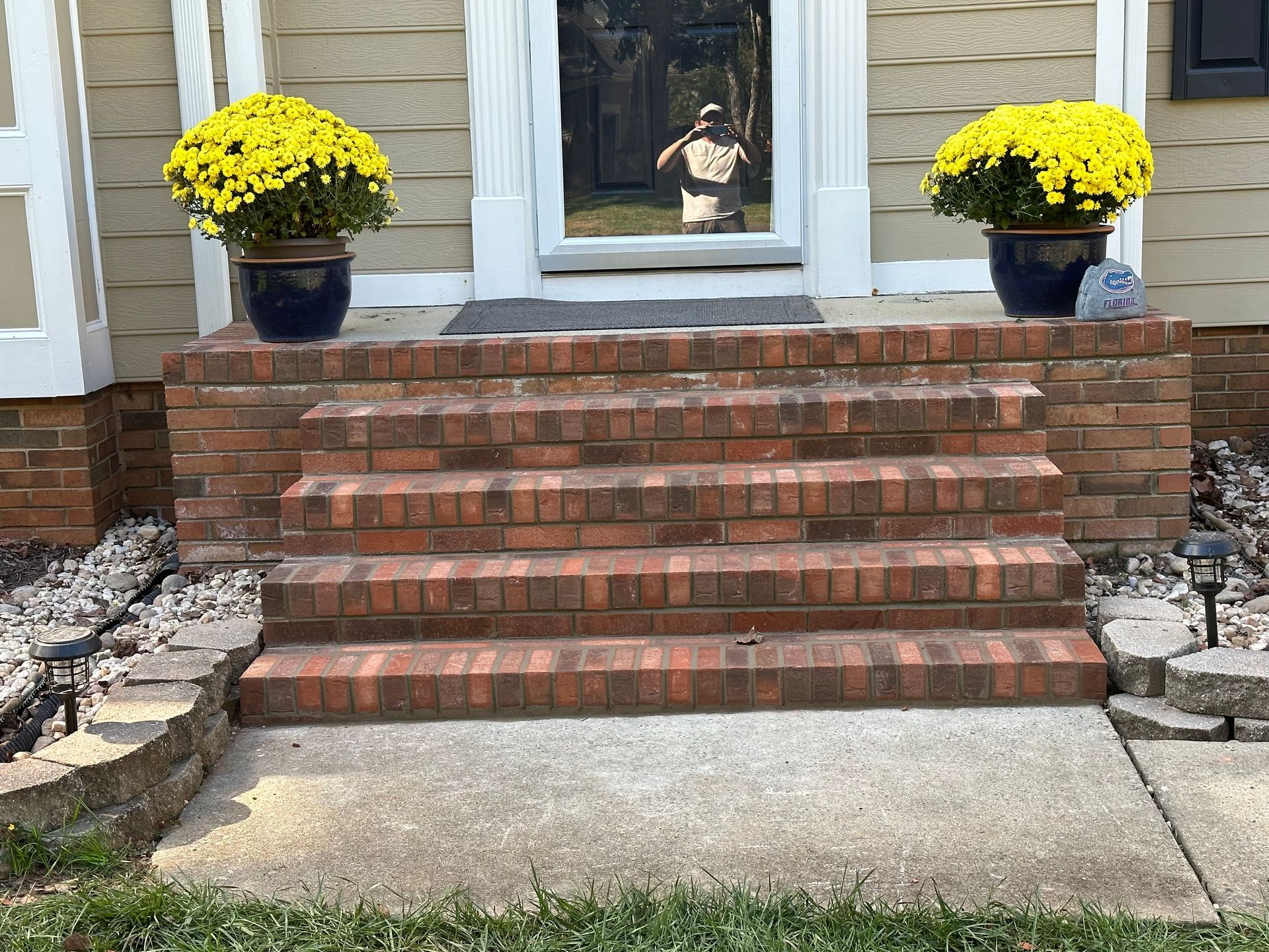 A set of brick steps leading up to the front door of a house.