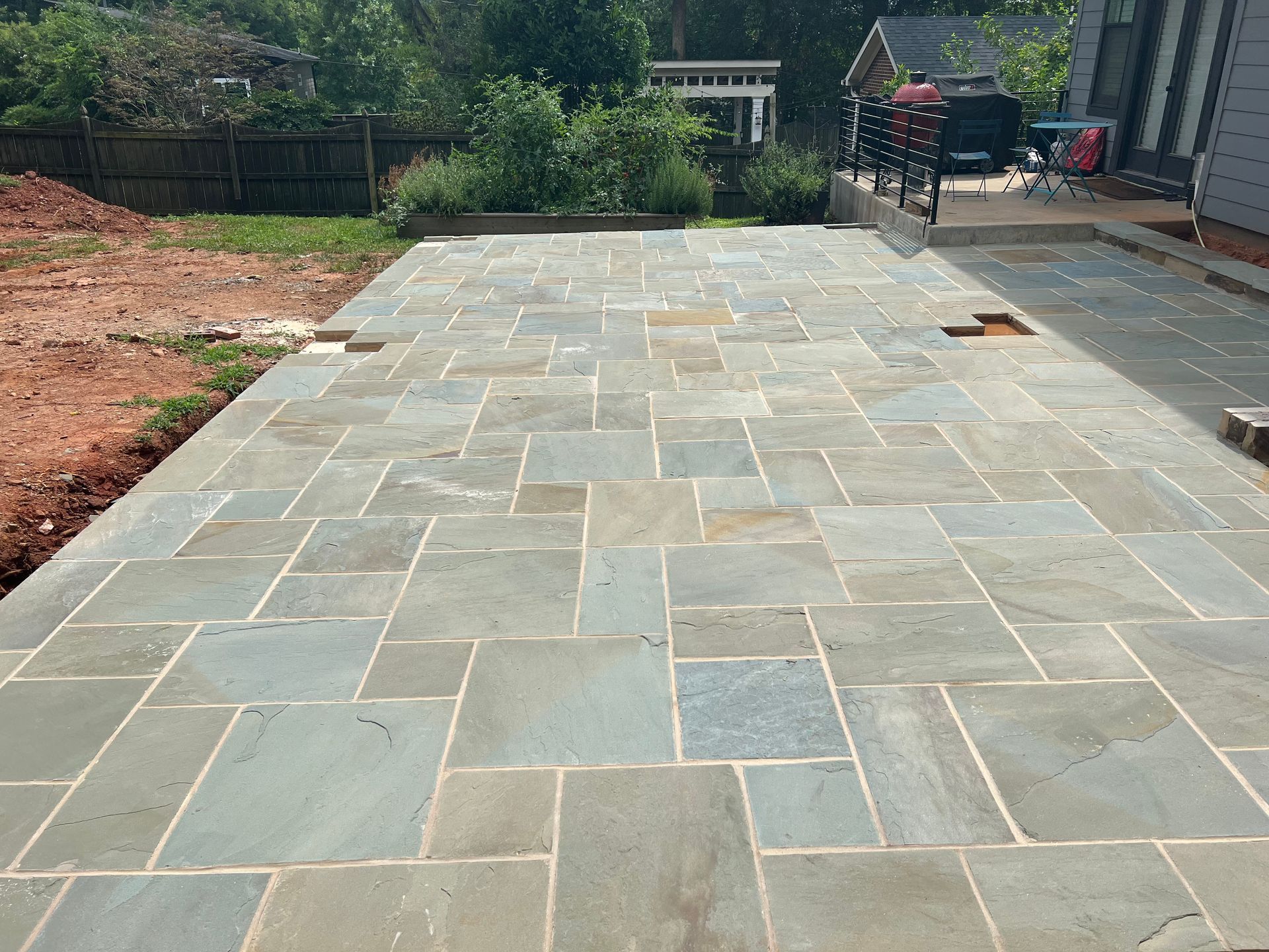 A brick driveway is being built in front of a house.