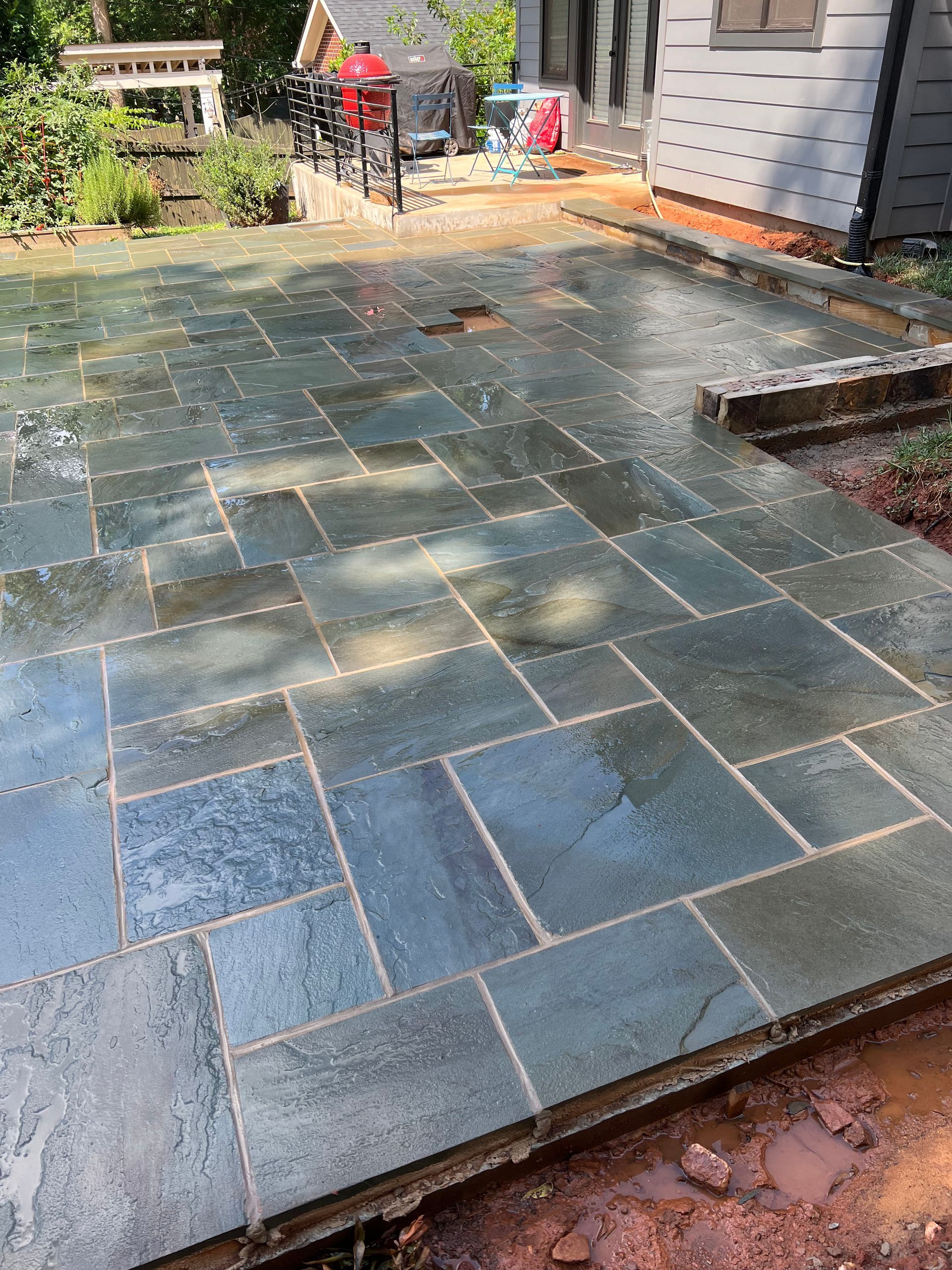 A stone patio is being built in front of a house.