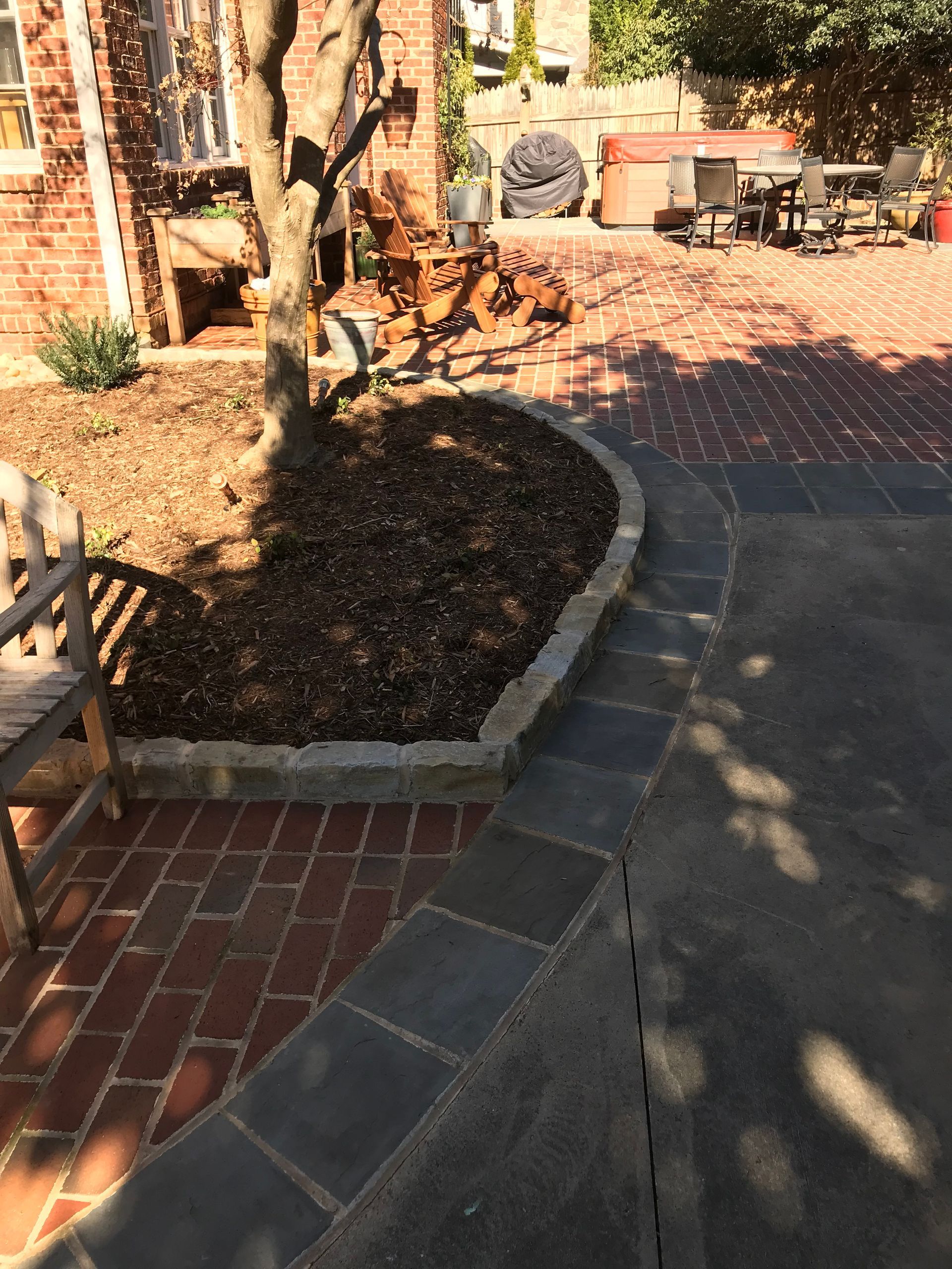 A brick patio with a tree in the middle of it