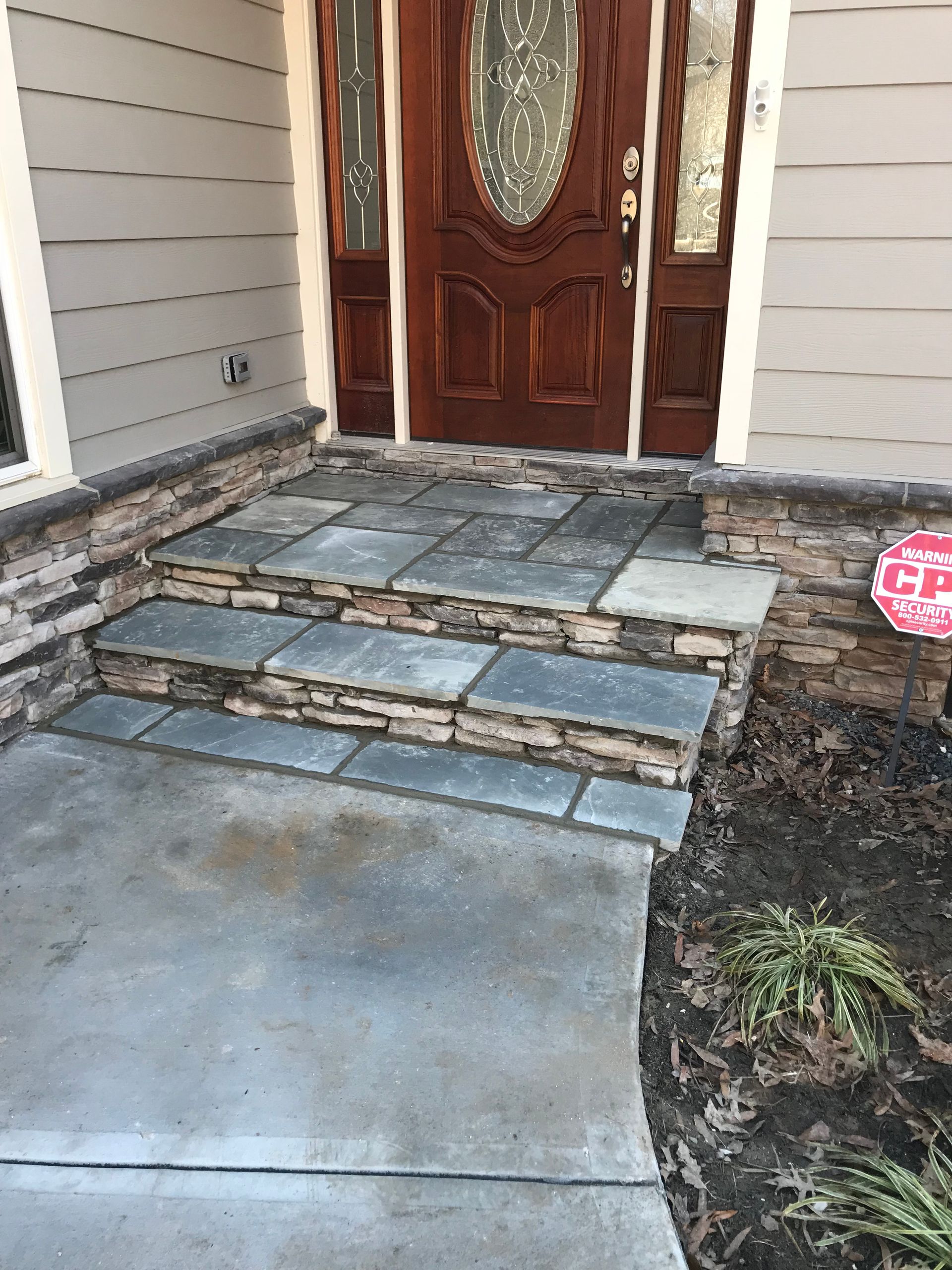A stone walkway leading to the front door of a house.