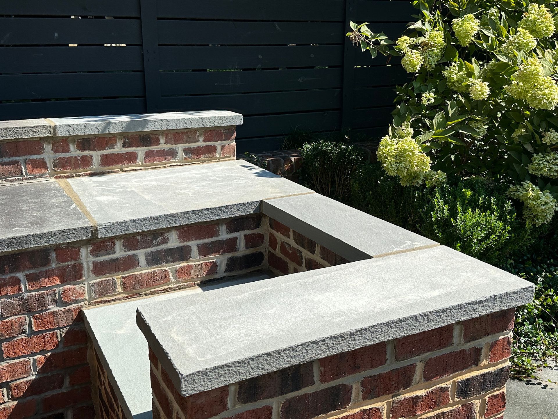 A brick wall with a concrete ledge on top of it