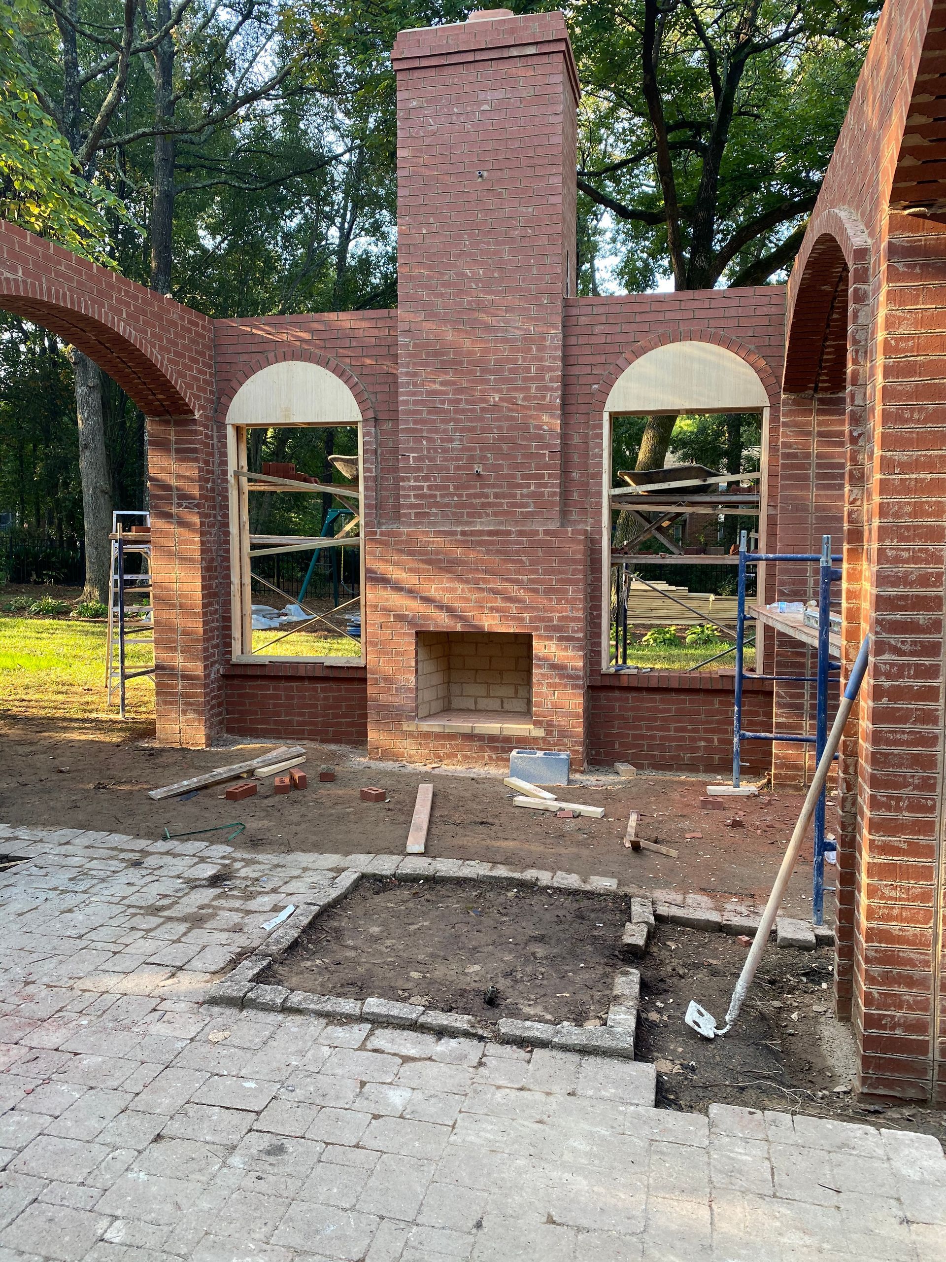 A brick building with a fireplace and arches is being built.