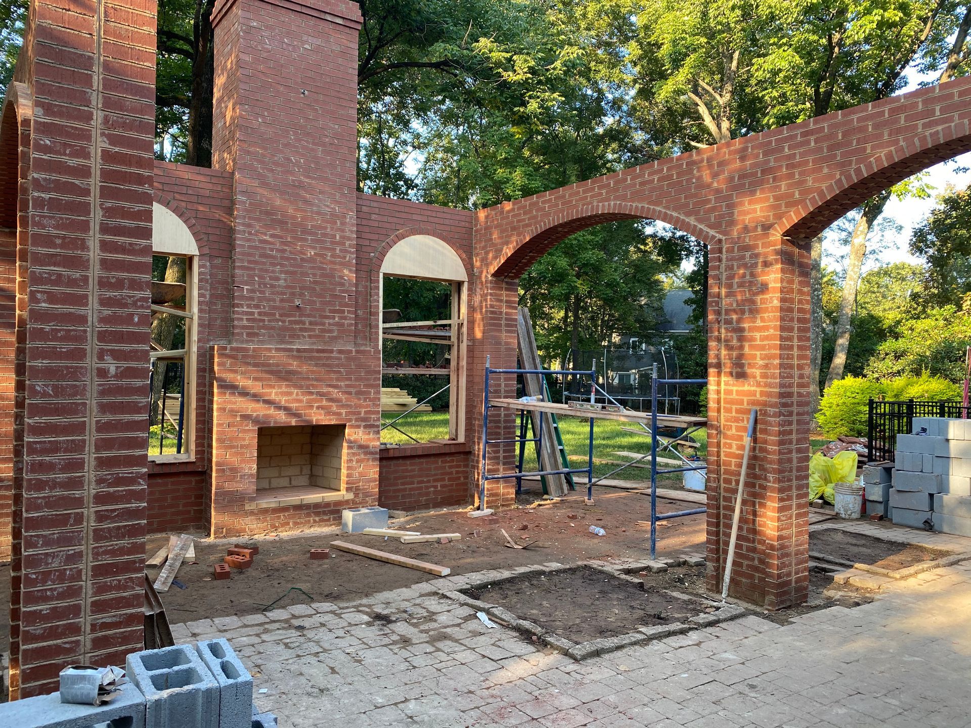A brick building under construction with arches and chimneys.