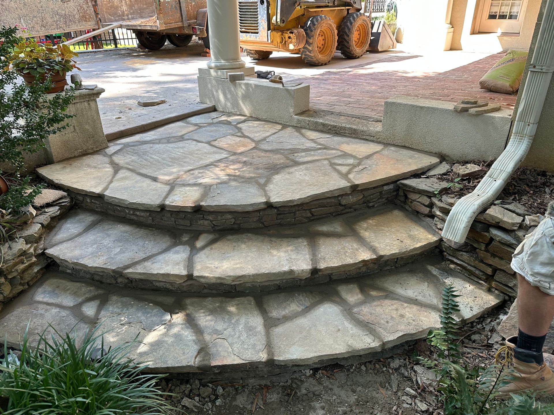 A person is standing next to a set of stone steps.