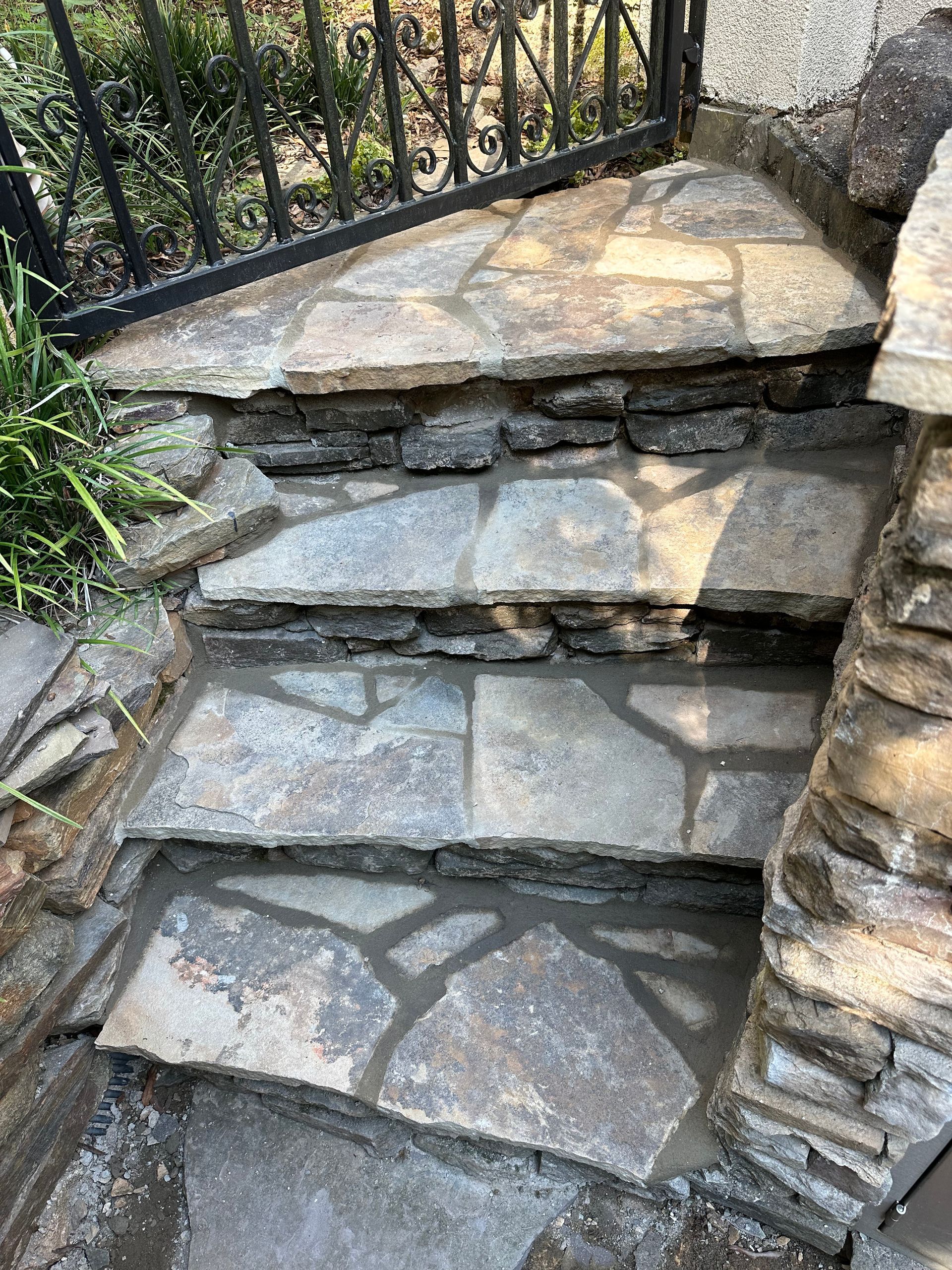 A set of stone steps leading up to a fence.