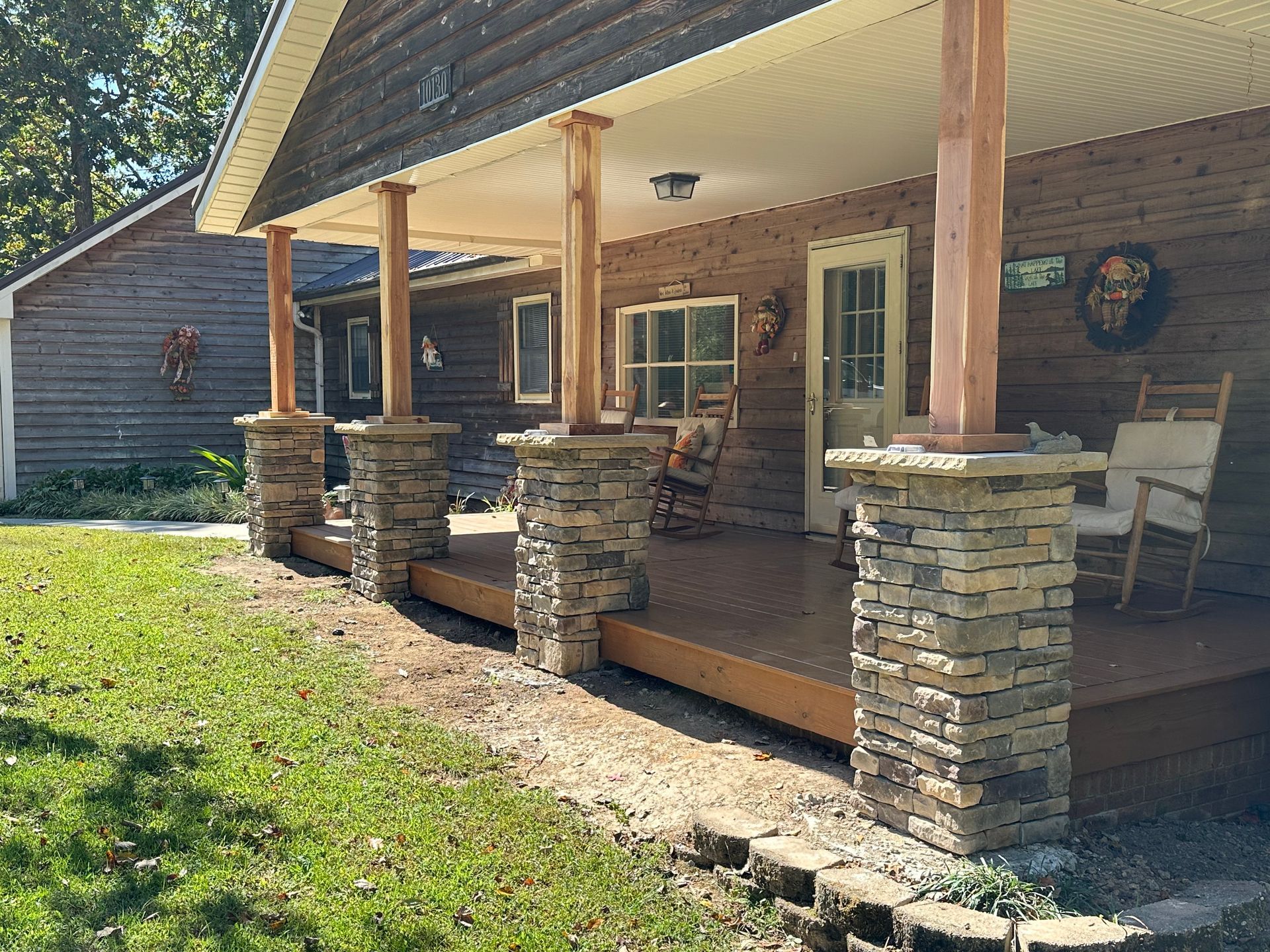 A porch with rocking chairs and a table on it