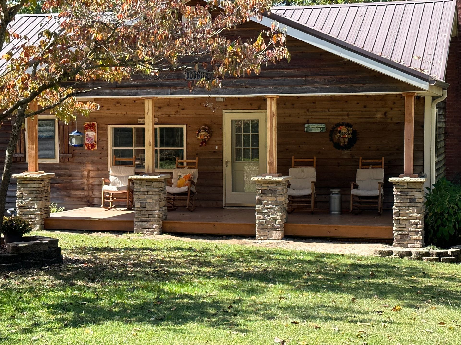 A log cabin with a porch and rocking chairs on it.