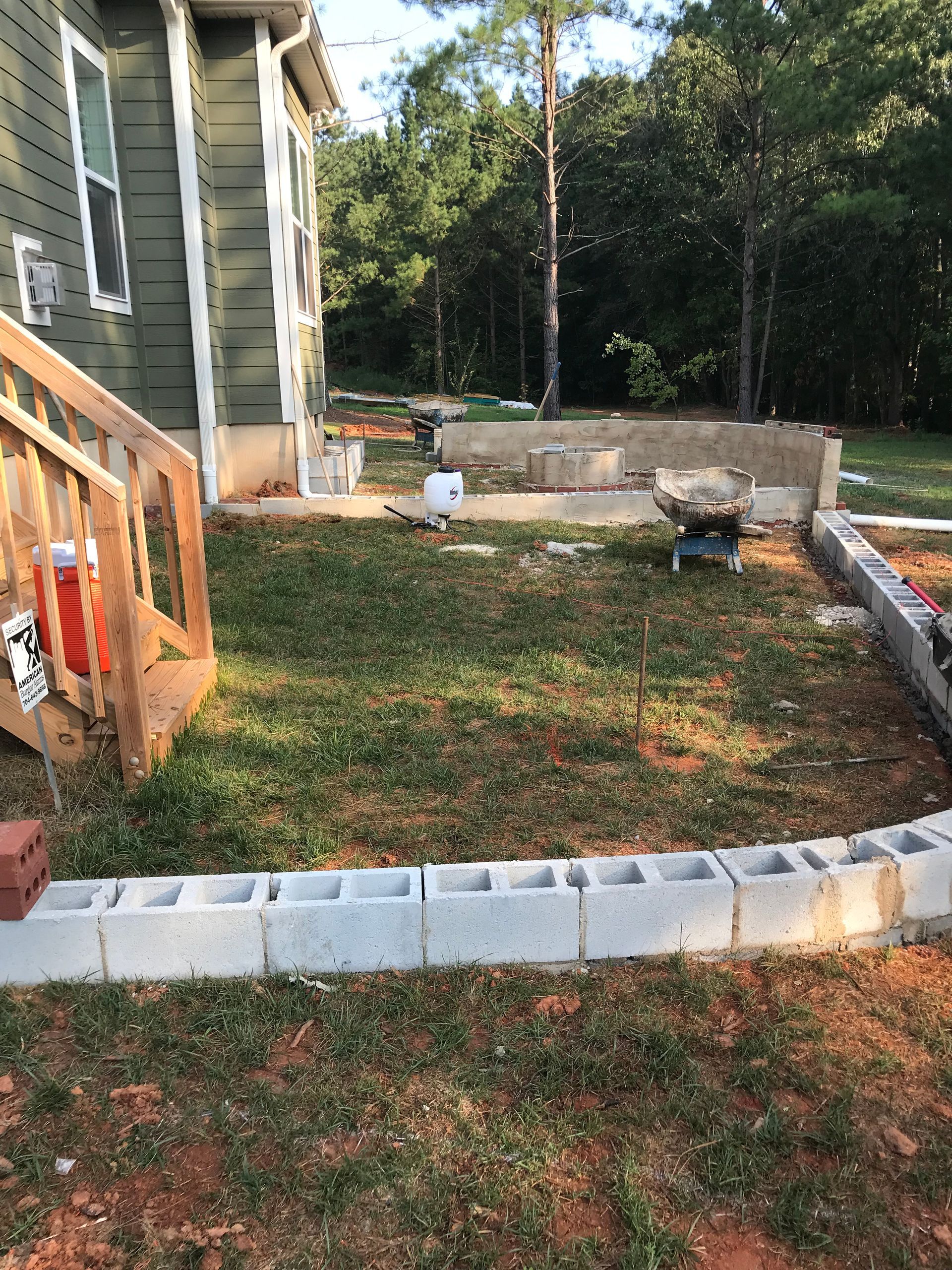 A brick border is being built in the backyard of a house.