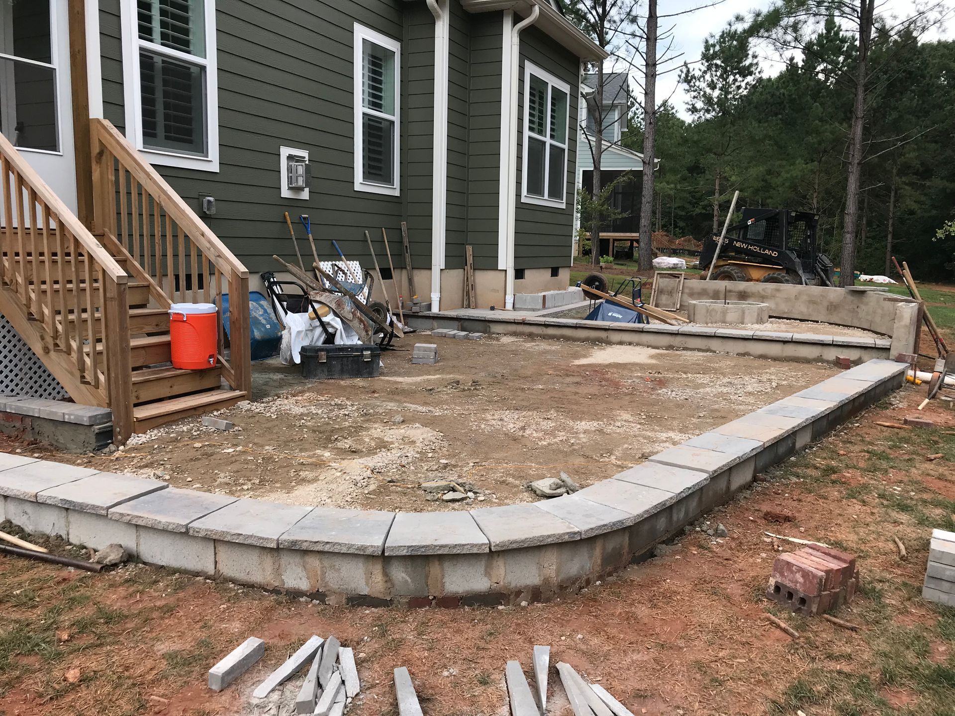 A patio is being built in front of a house.