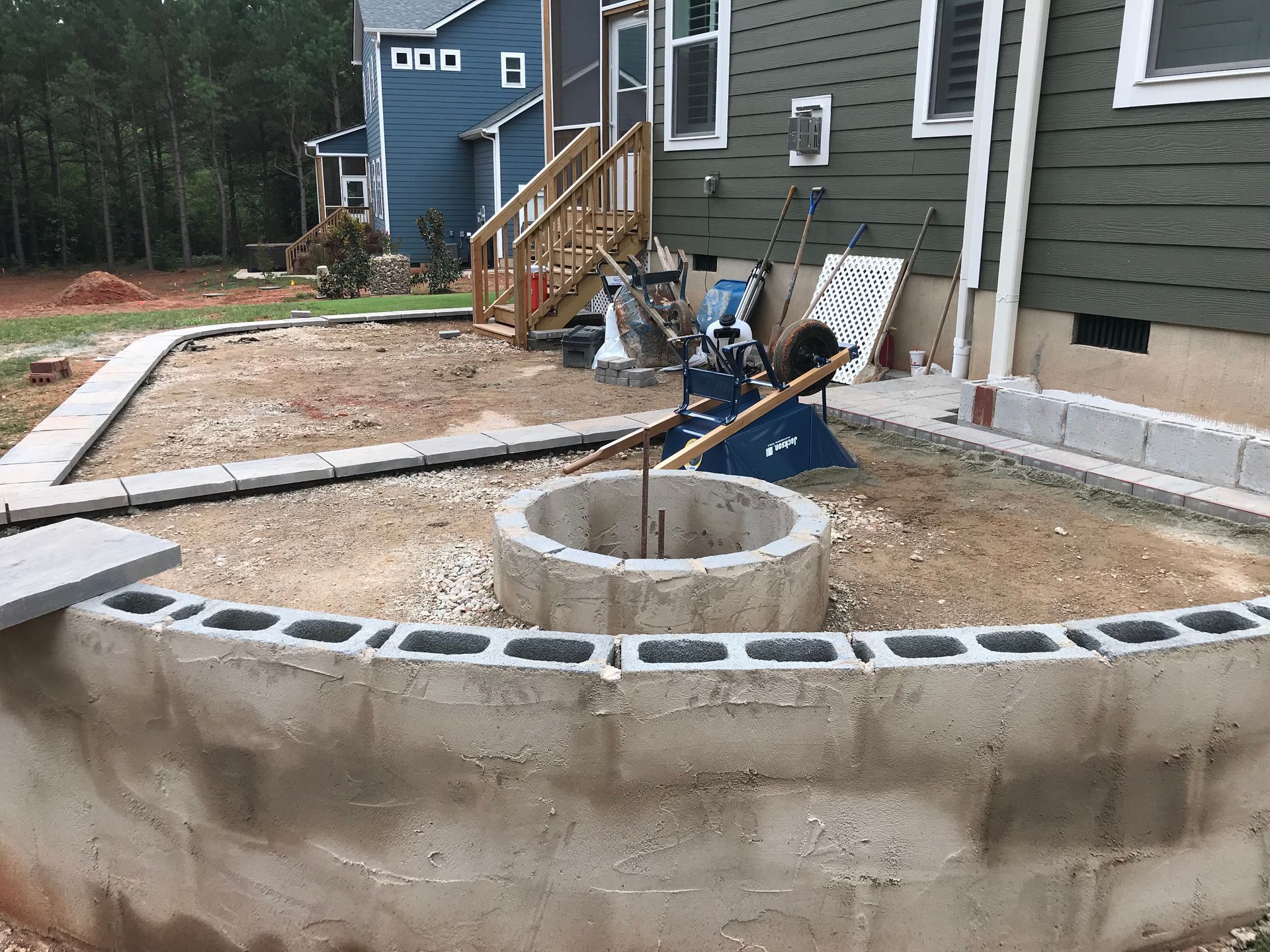 A fire pit is being built in front of a house.