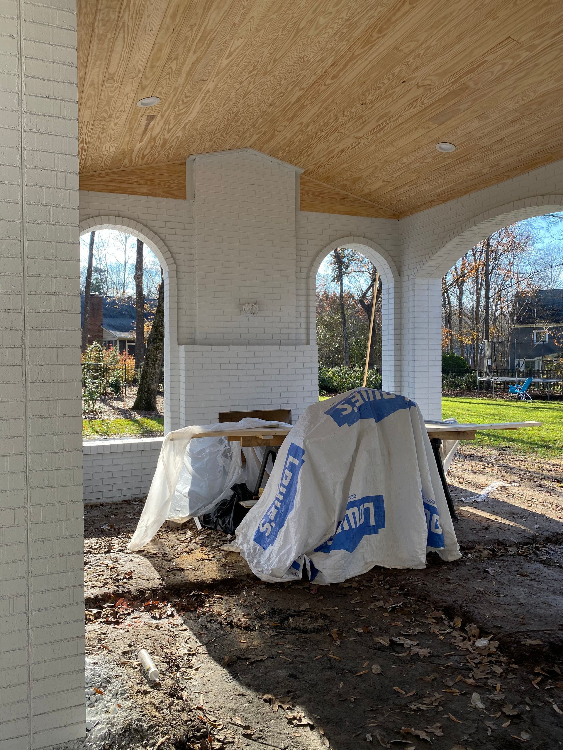 A white brick building under construction with a wooden ceiling.
