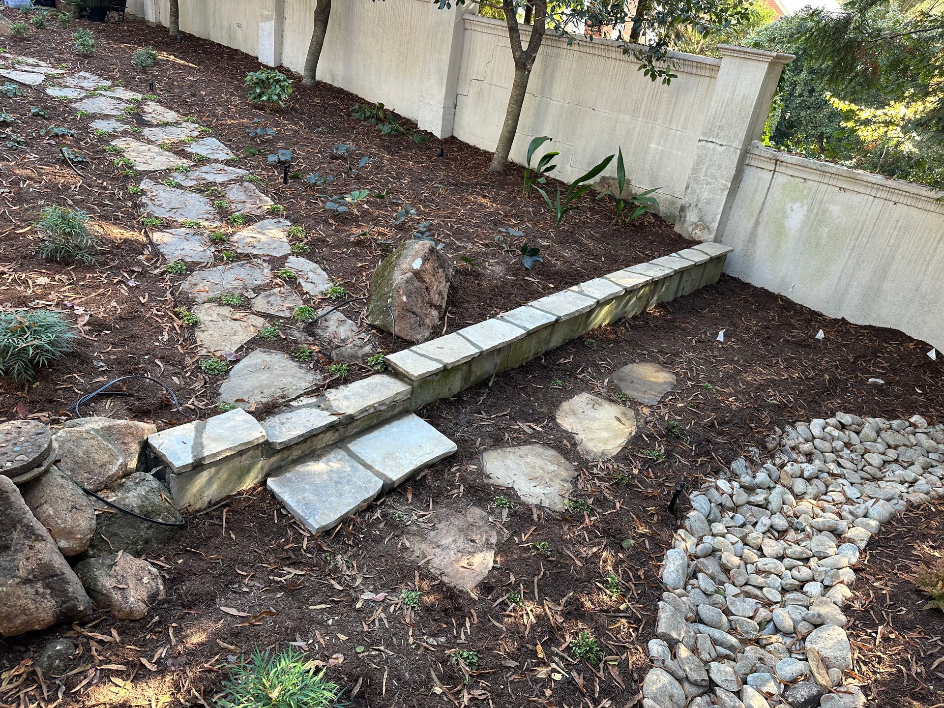 There is a stone walkway in the middle of the garden.