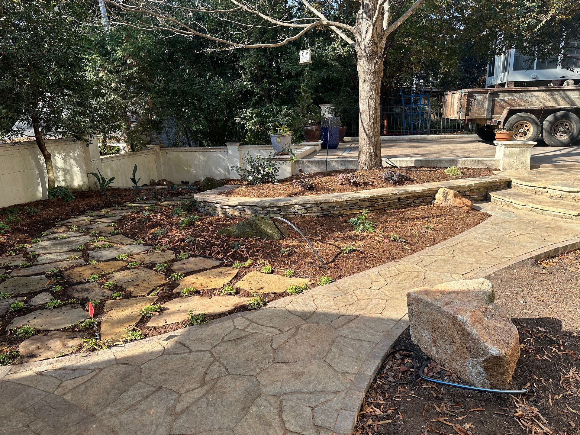 A truck is parked in a driveway next to a stone walkway.