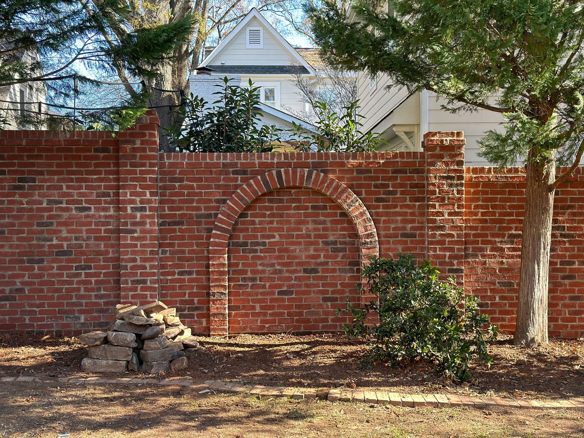 A brick wall with an arch in the middle of it