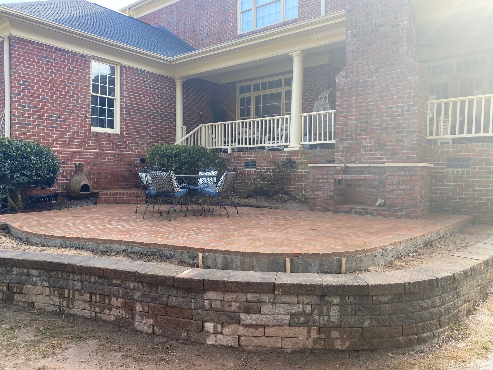 A large brick house with a patio in front of it.