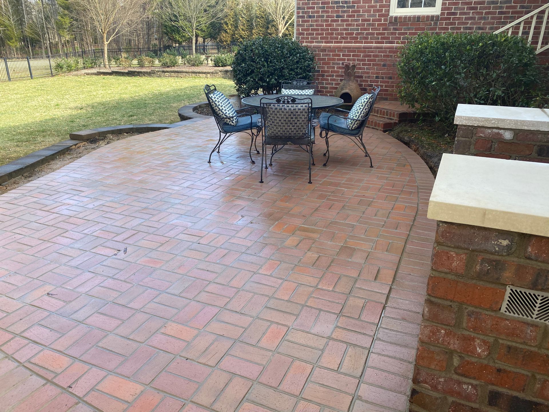 A brick patio with a table and chairs on it